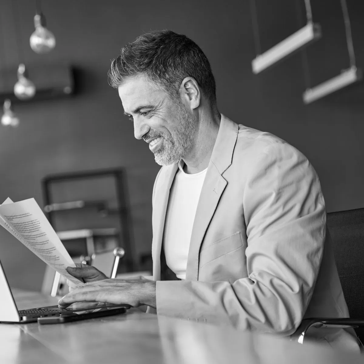 Legal leader reviewing printed documents beside a laptop